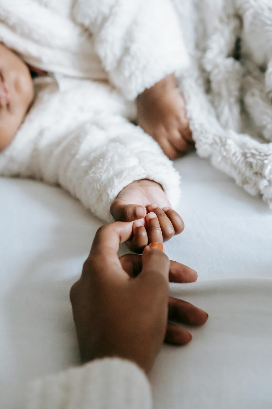 mother holding baby's hand