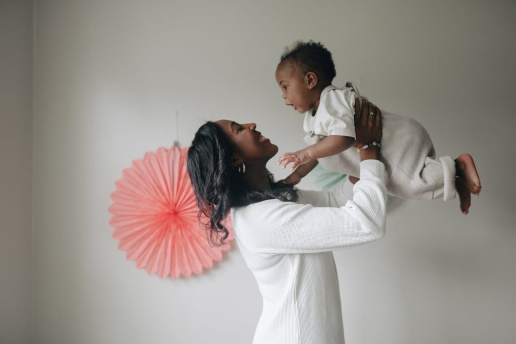 Mother playfully lifting baby up