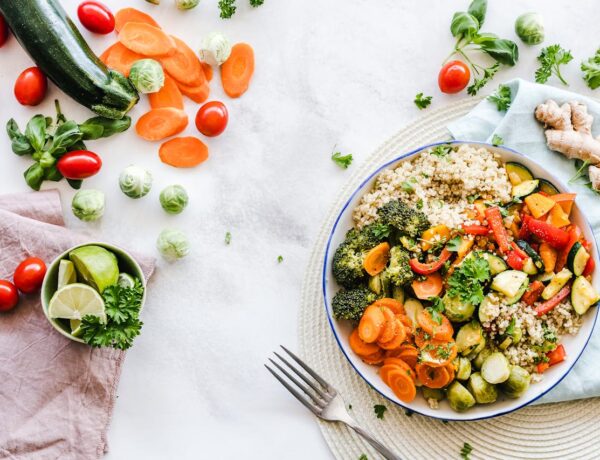 a plate of vegetables and quinoa on a set table