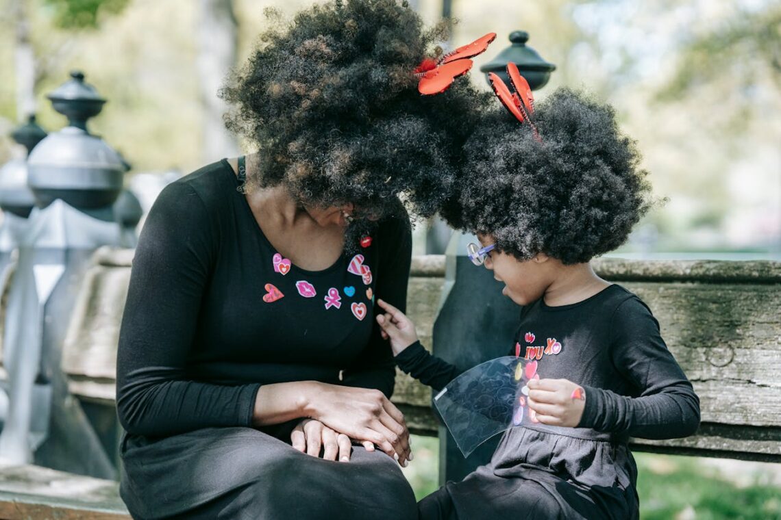 A woman and a child with afro hair wearing black