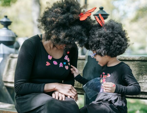 A woman and a child with afro hair wearing black