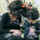 A woman and a child with afro hair wearing black