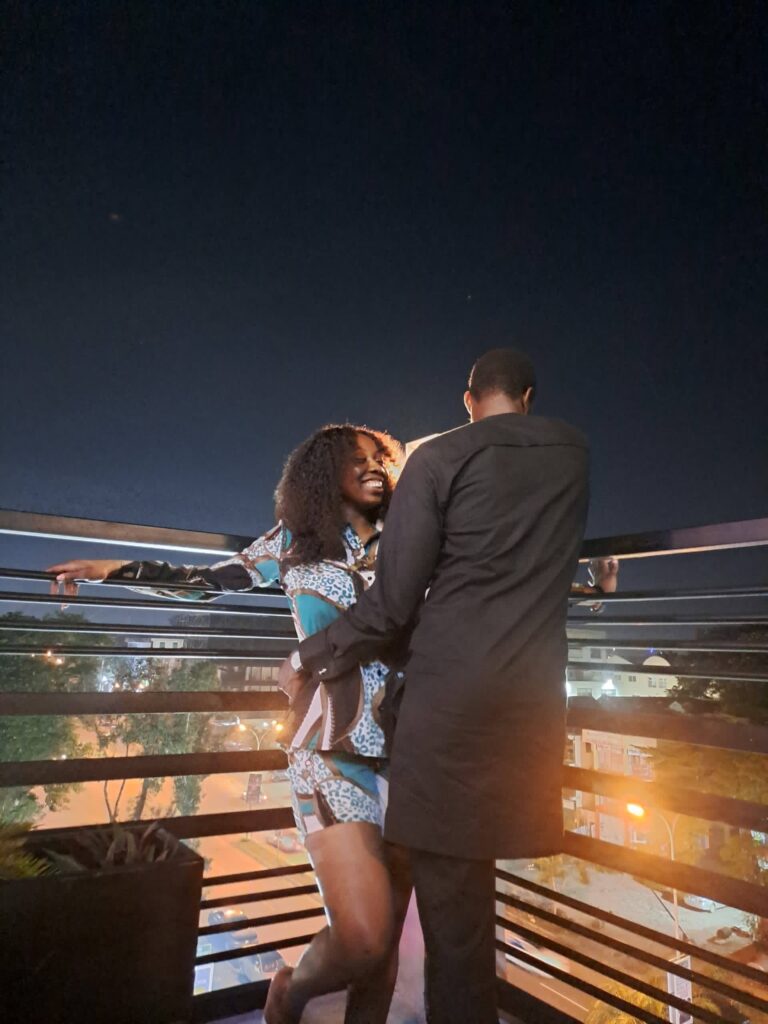 Man backing camera and holding woman smiling